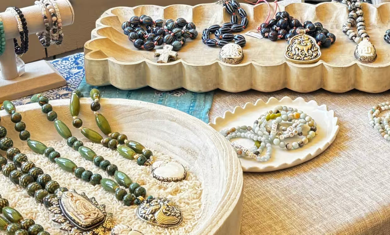 Jewelry display with necklaces and bracelets on awooden trays and a textured surface